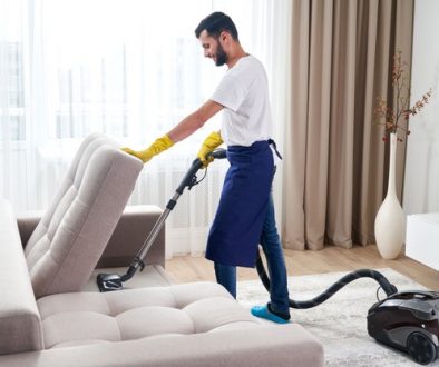 young-man-cleaning-sofa-with-vacuum-cleaner-leaving-room-home_130111-3594
